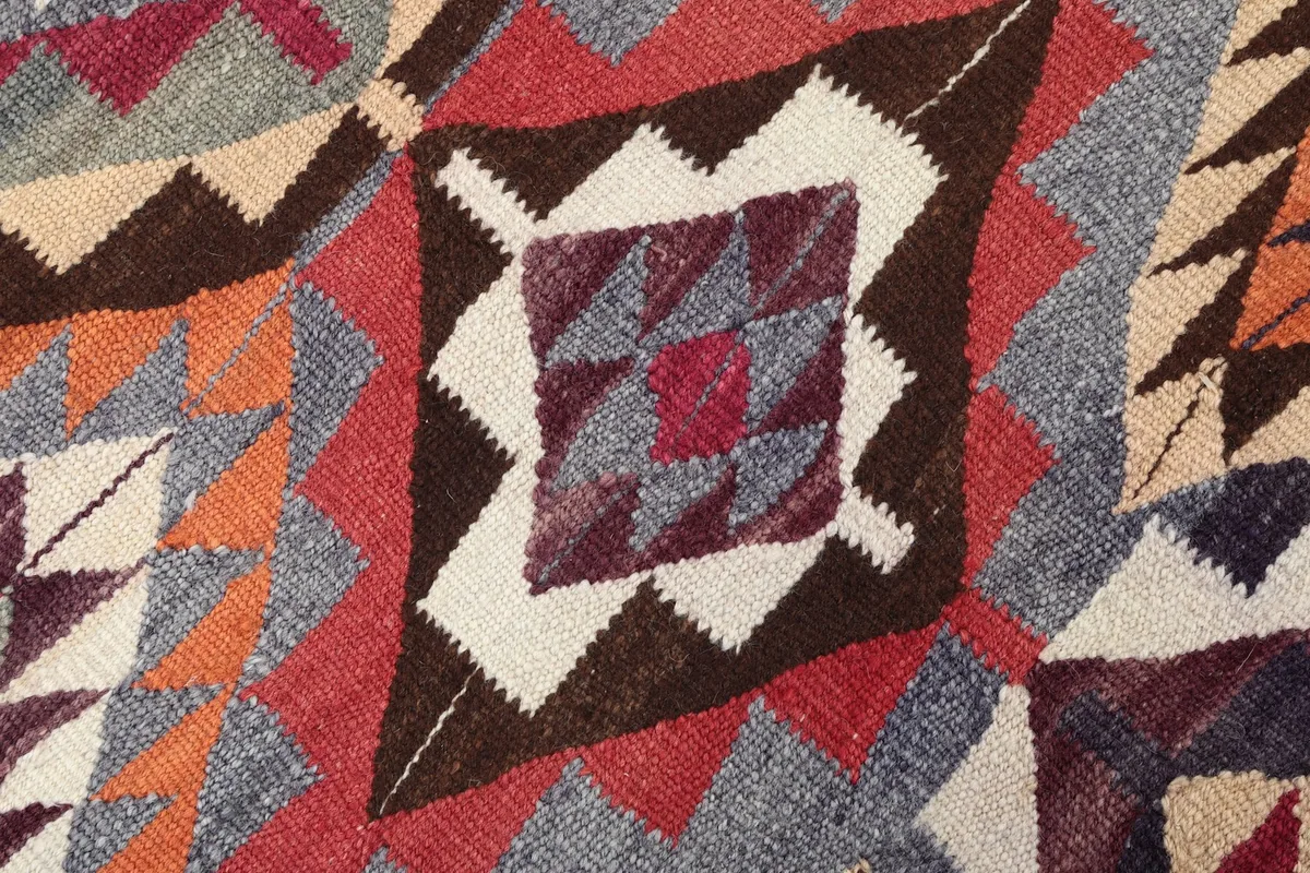Close-up of a central geometric motif with red, blue, ivory, and brown colors