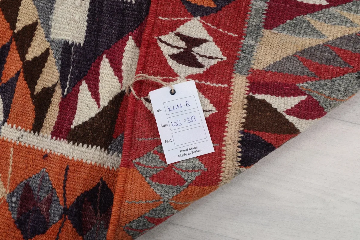 Close-up of the rug's label showing size 103x333 cm and 'Hand Made in Turkey'