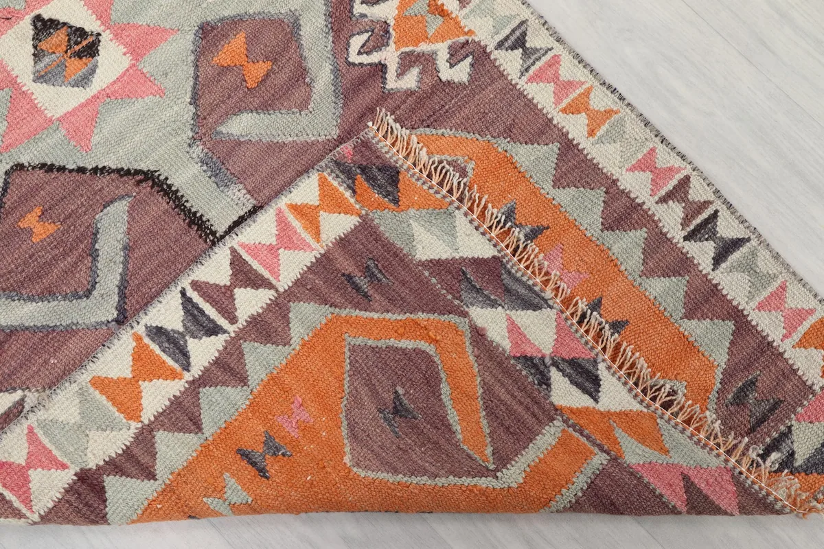 Folded corner of the rug, revealing the thickness of the wool pile and the hand-knotted construction.