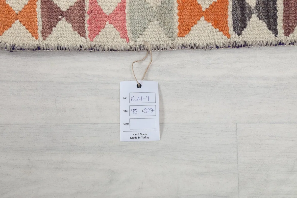 Product tag displaying the rug's dimensions in centimeters and inches, confirming its origin and material.