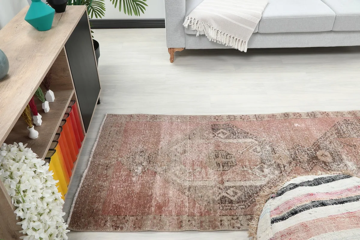 Runner rug extending from an ottoman towards a sofa in a home decor setting