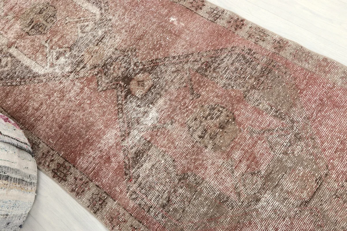 Close-up of the central area of the rug, revealing faded geometric designs and texture