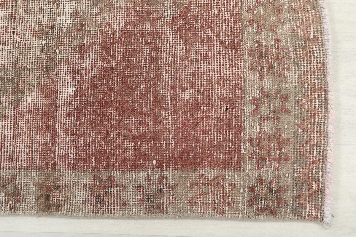 Detail of the rug's border and corner, highlighting its subtle patterns and color variations