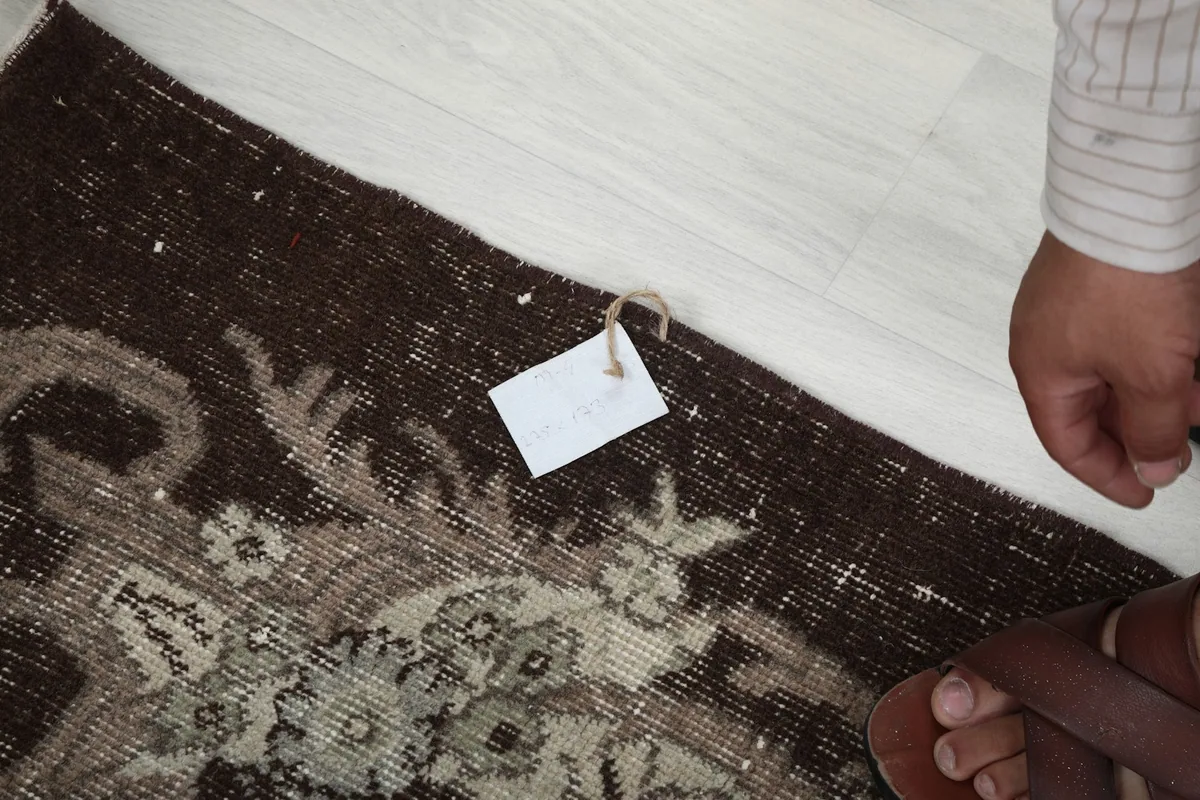 Detail of the rug's edge with a tag, showing the craftsmanship