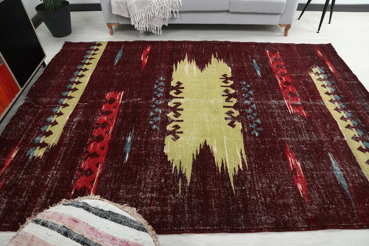 Vintage rug laid out in a room, offering a perspective on its size and impact