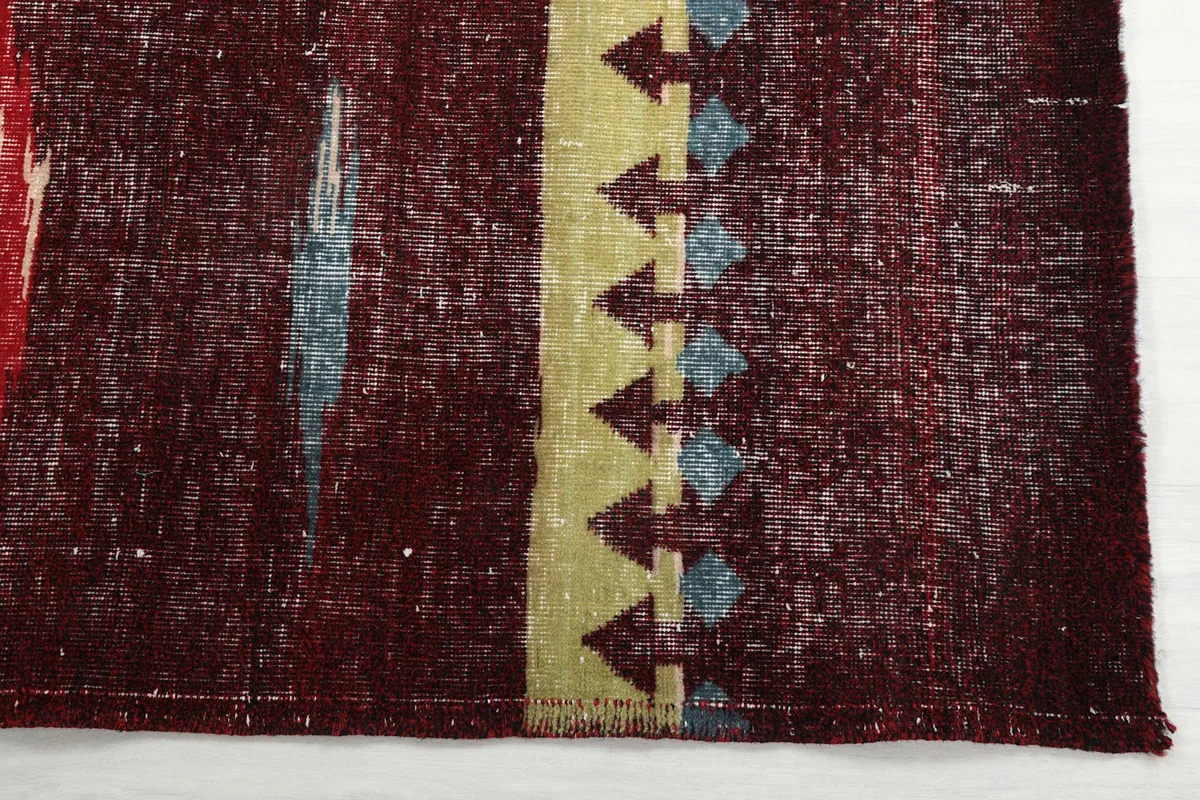 Detail of the rug's border area with yellow geometric shapes and blue accents