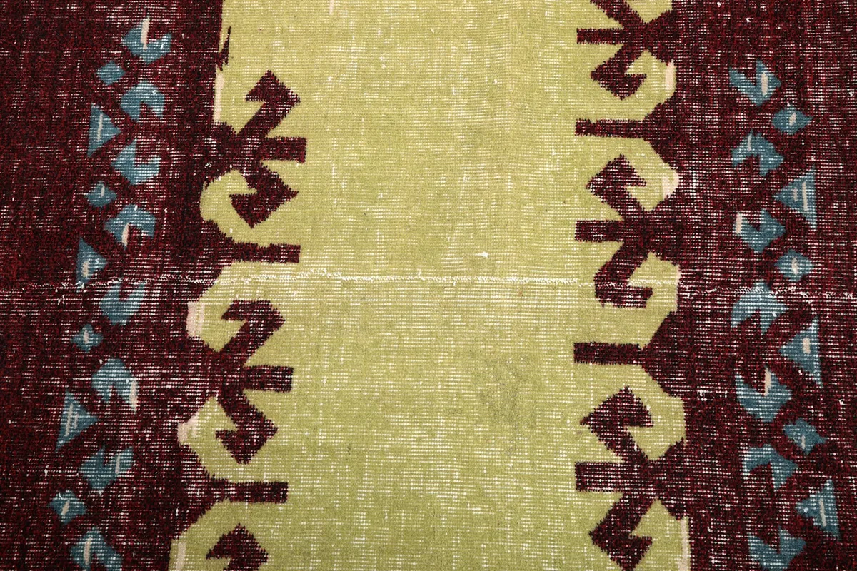 Close-up detail of the central yellow motif with intricate geometric patterns in blue