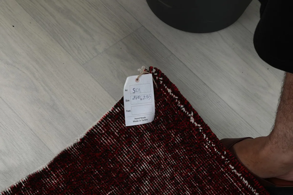 Close-up of the rug's edge and fringe, showing the professional cleaning tag