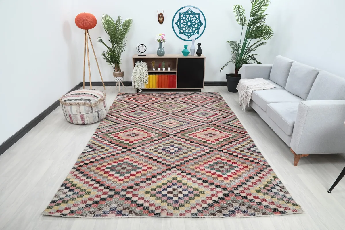 Vintage multicolor geometric area rug displayed in a modern living room setting with a light gray sofa.