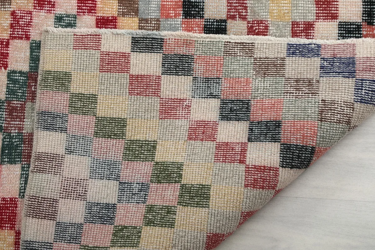 Close-up of the low wool pile and the intricate hand-knotted construction of the vintage rug.