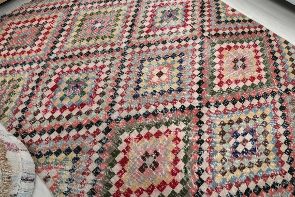 Overhead view showing the repeating diamond geometric patterns of the multicolor vintage Anatolian rug.