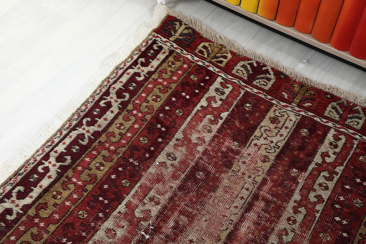 Corner detail of the runner rug, showing the blend of red, beige, and olive colors in the pattern.