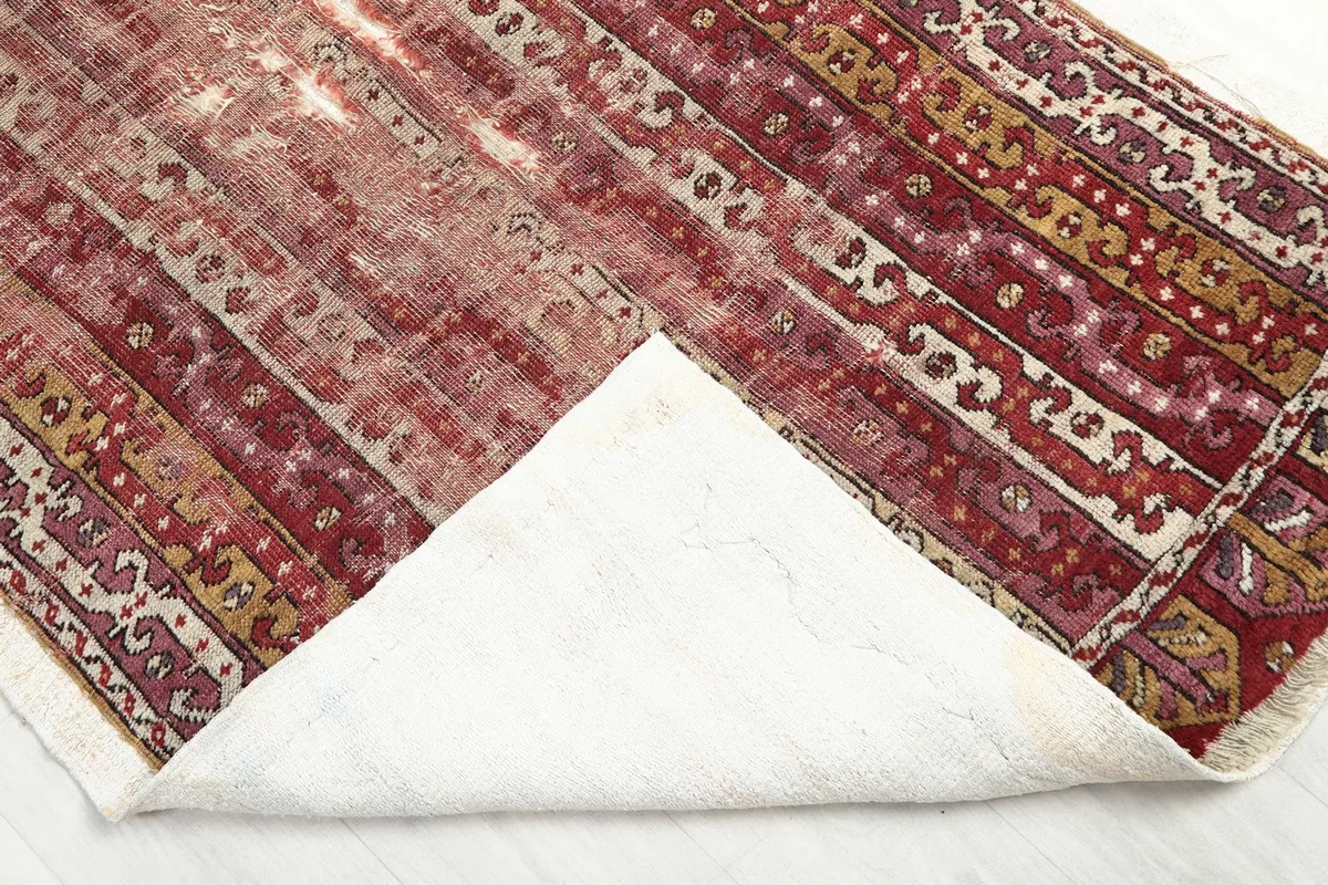 Angle view of the rug's underside, showing the sturdy cotton foundation and craftsmanship.