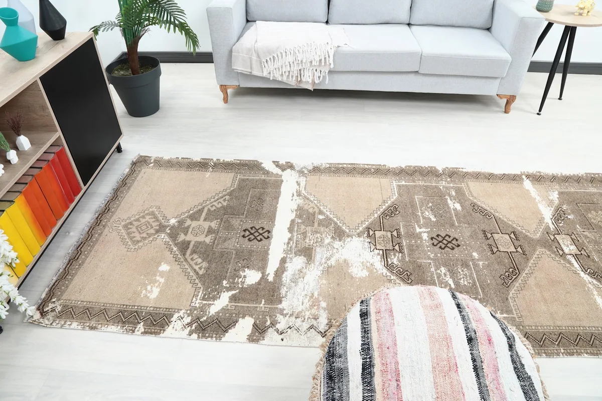 Runner rug in a room, with a pouf in the foreground and a sofa in the background