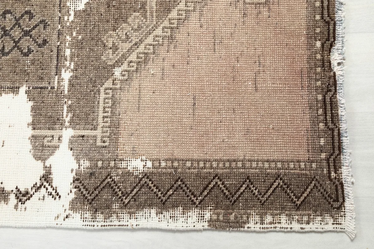 Close-up of the low pile and distressed texture, revealing the cotton foundation