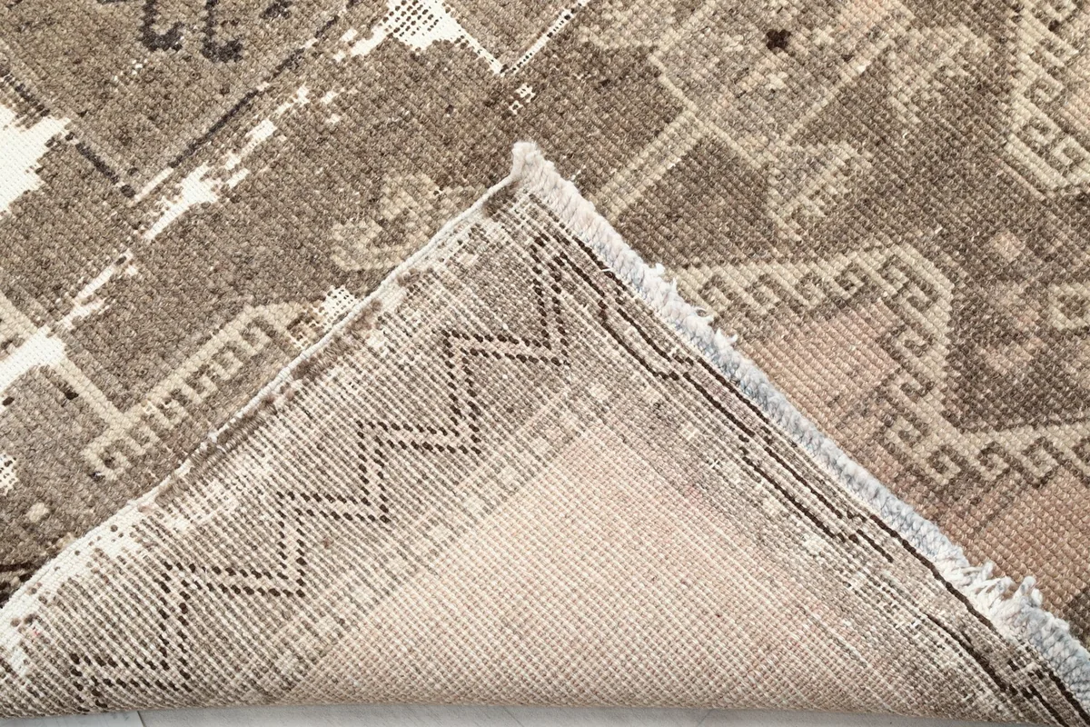 Folded corner showing the reverse side of the hand-knotted wool rug