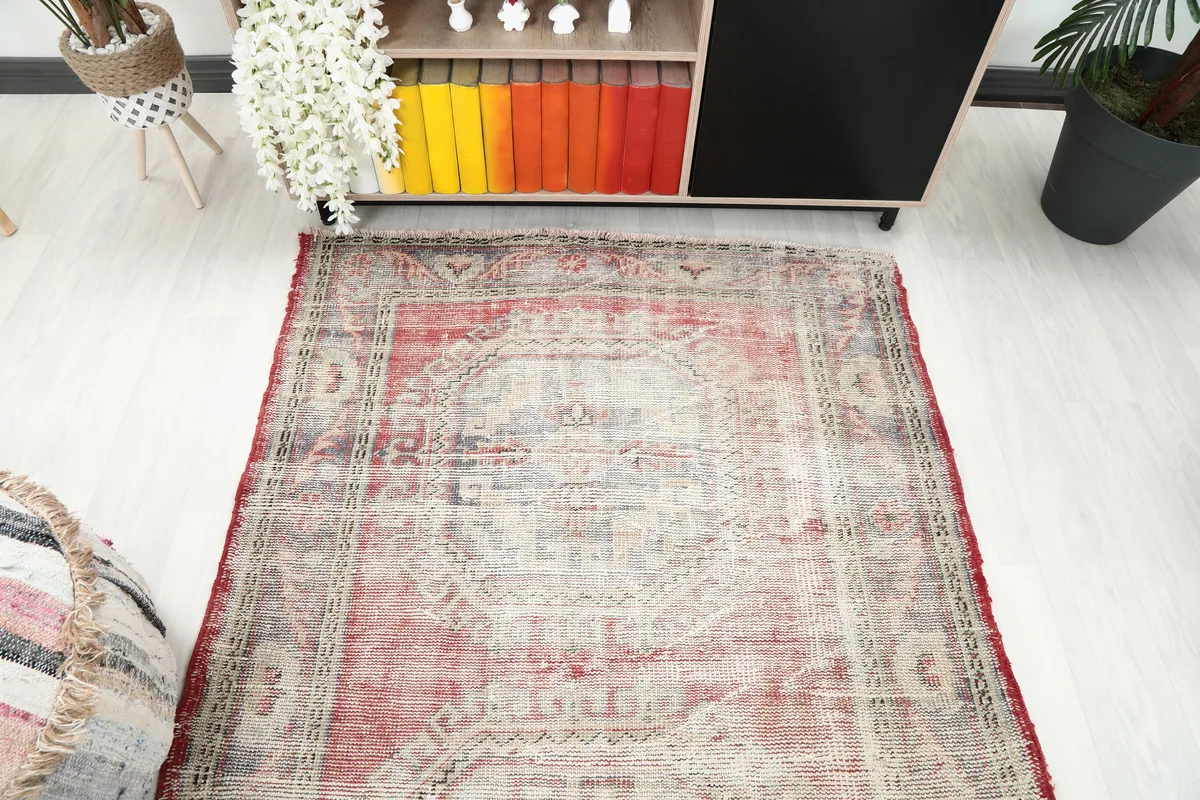 Faded Red Geometric Anatolian Runner placed in a room, viewed from above