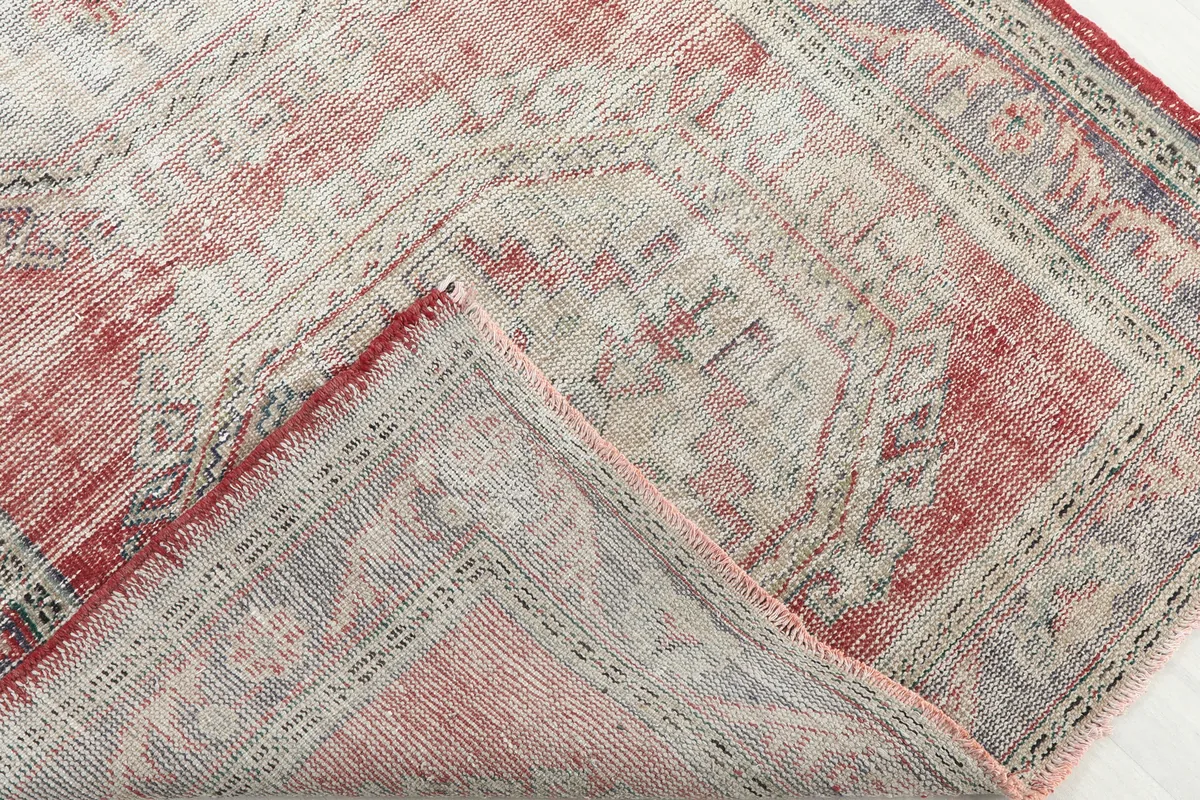 Folded corner of the Faded Red Geometric Anatolian Runner showing the cotton foundation