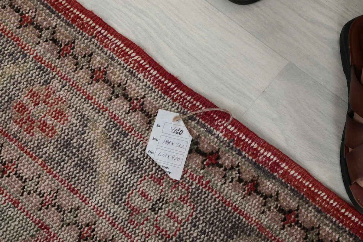 Edge of the rug showing the hand-finished details and the attached product tag