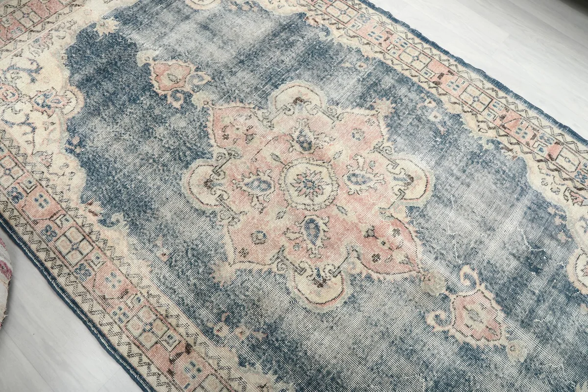Overhead angle showcasing the central rose medallion and navy field of the rug