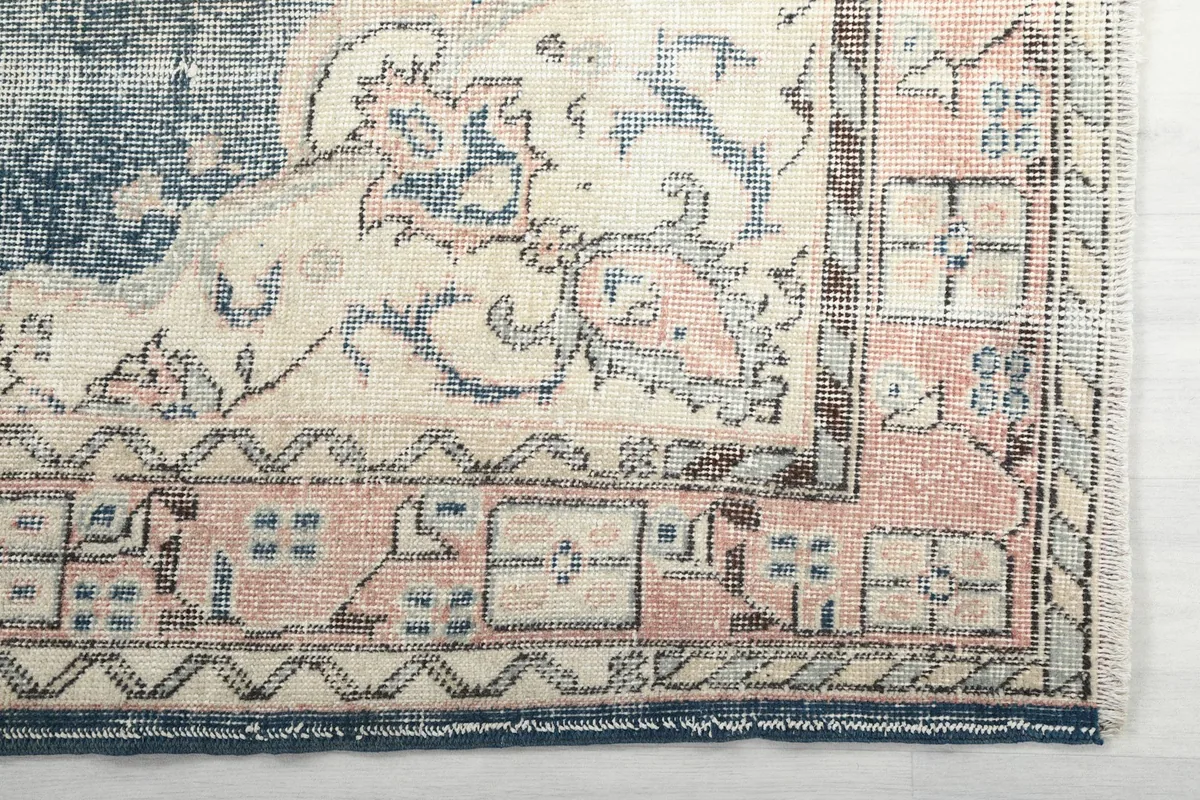 Detailed view of the corner border with cream and rose geometric patterns