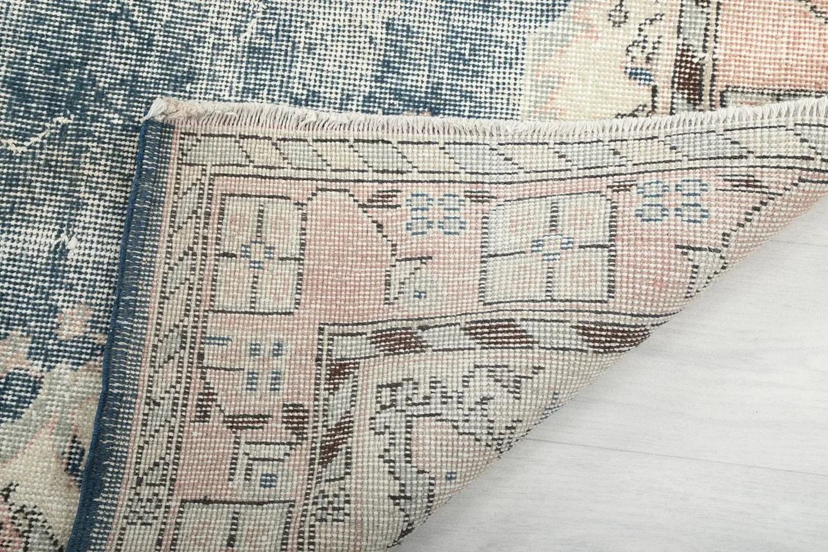 Underside of the rug showing the reverse of the rose and cream border