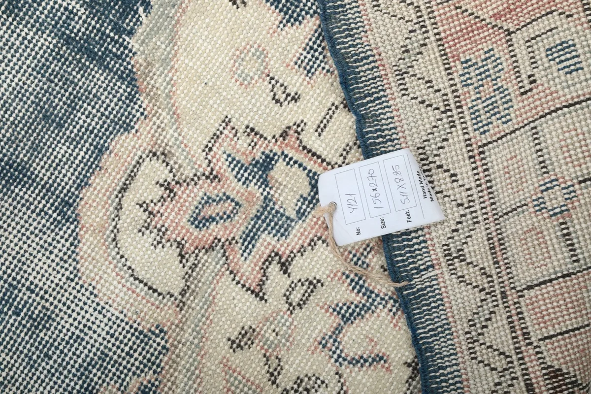 Close-up of the rug's reverse side with a tag indicating its dimensions