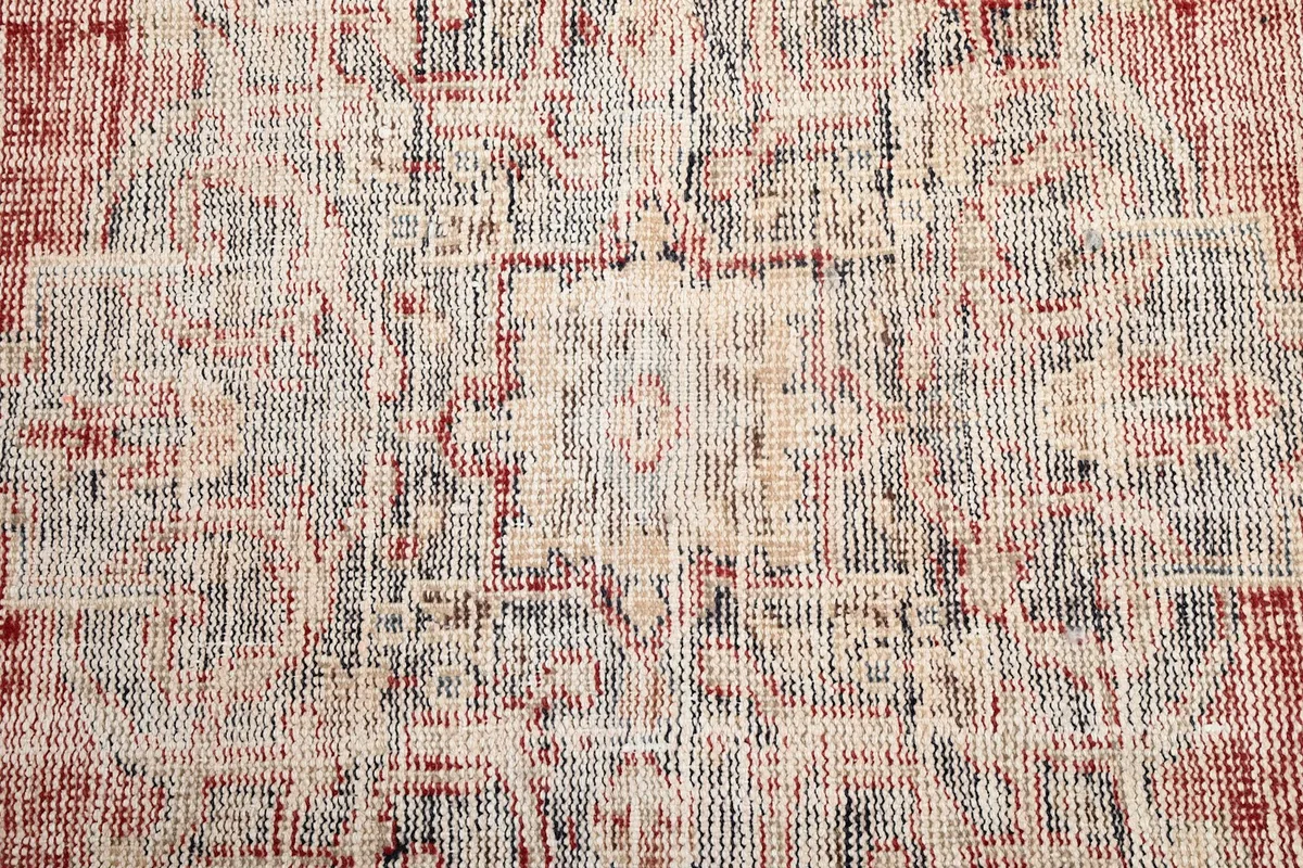 Close-up showing the intricate, faded geometric motifs within the rug's design