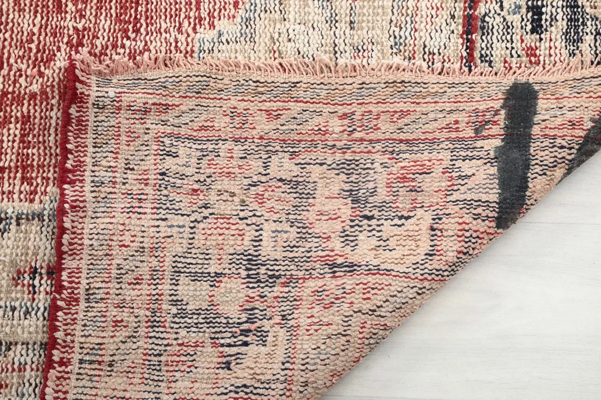 Close-up of the back of the rug, showing the hand-knotted construction and cotton foundation