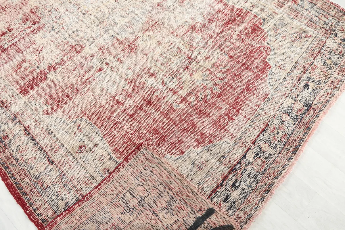 Corner of the rug folded back, revealing the reverse side and knotting