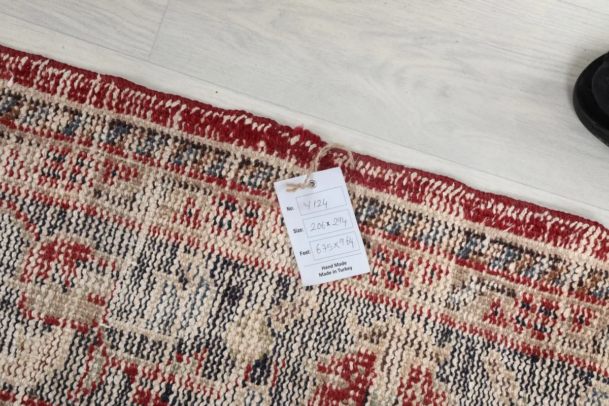 Detail of the rug's edge with a product tag displaying size and origin information