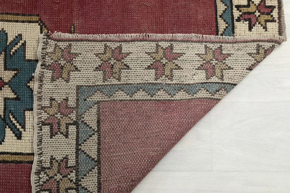 Close-up of the rug's pile and fringe, showing the texture and the vintage wear