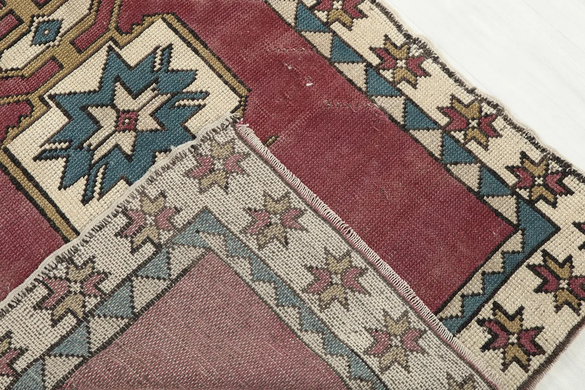 Corner of the rug folded to show the hand-knotted wool pile and cotton foundation from the back