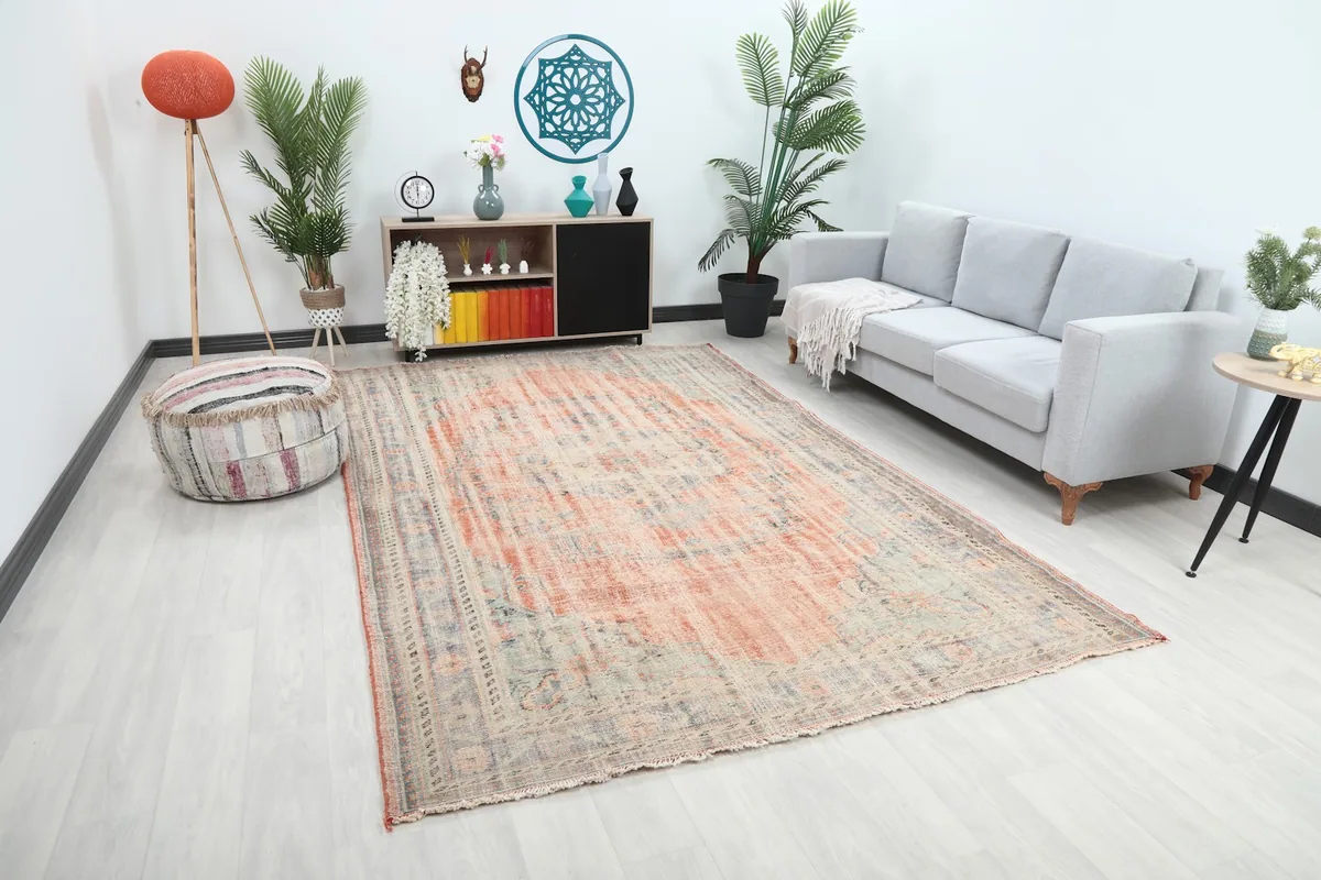 Angle view of the large vintage rug in a living room, showing its scale relative to the furniture.