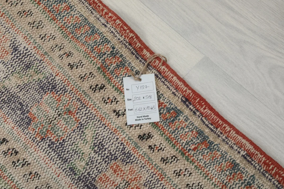 Rug corner with a product tag detailing dimensions and origin, showing the hand-made quality.