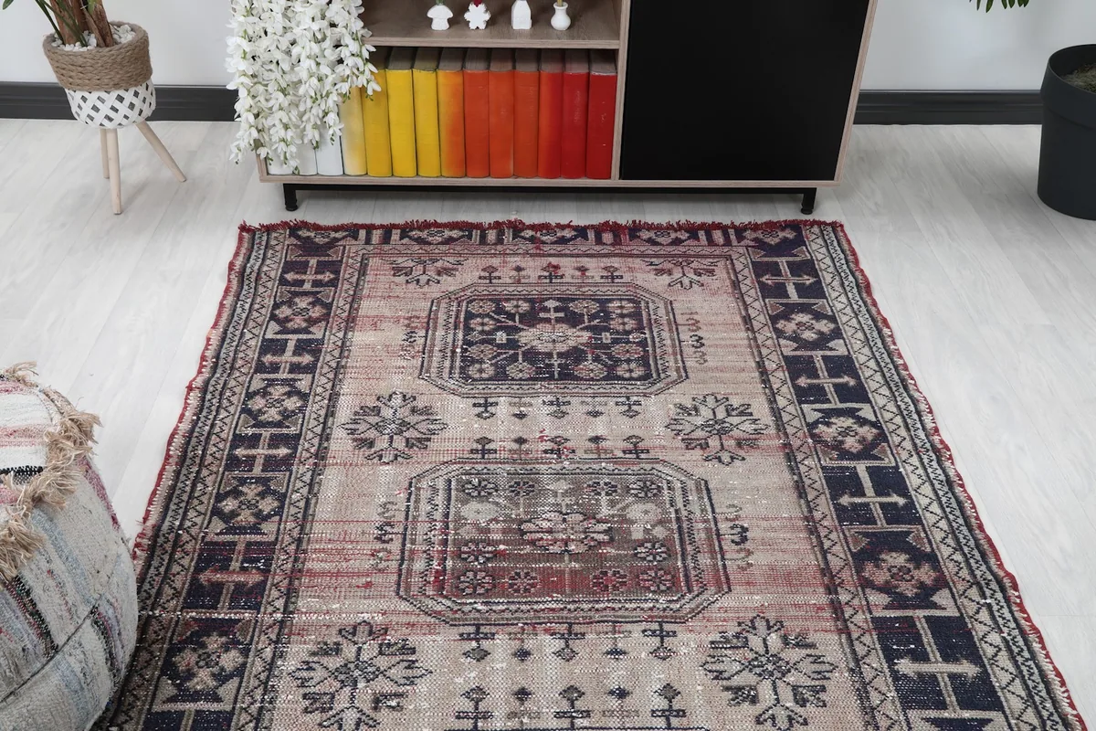 Overhead view of the rug in a room, looking towards a cabinet with colorful books