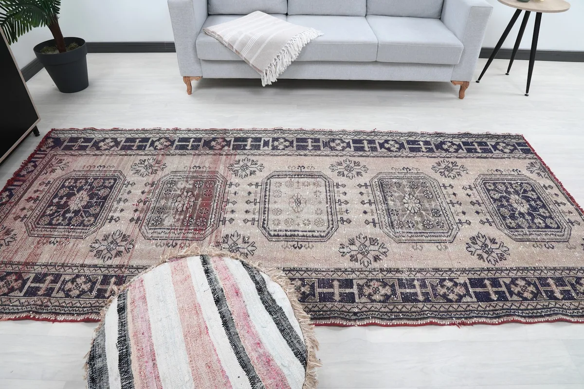 Wide overhead shot of the rug in a room, with a sofa and pouf