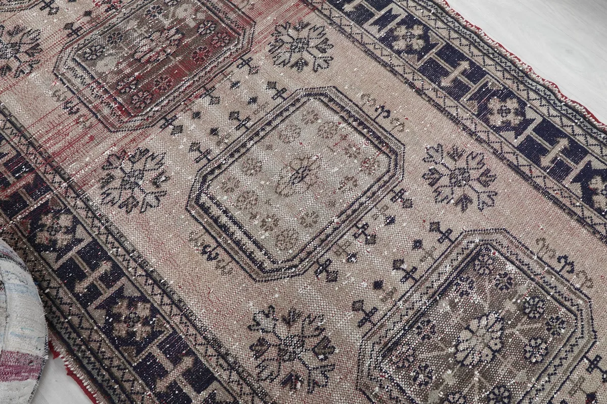 Close-up showing the central motifs and the subtle color variations on the rug