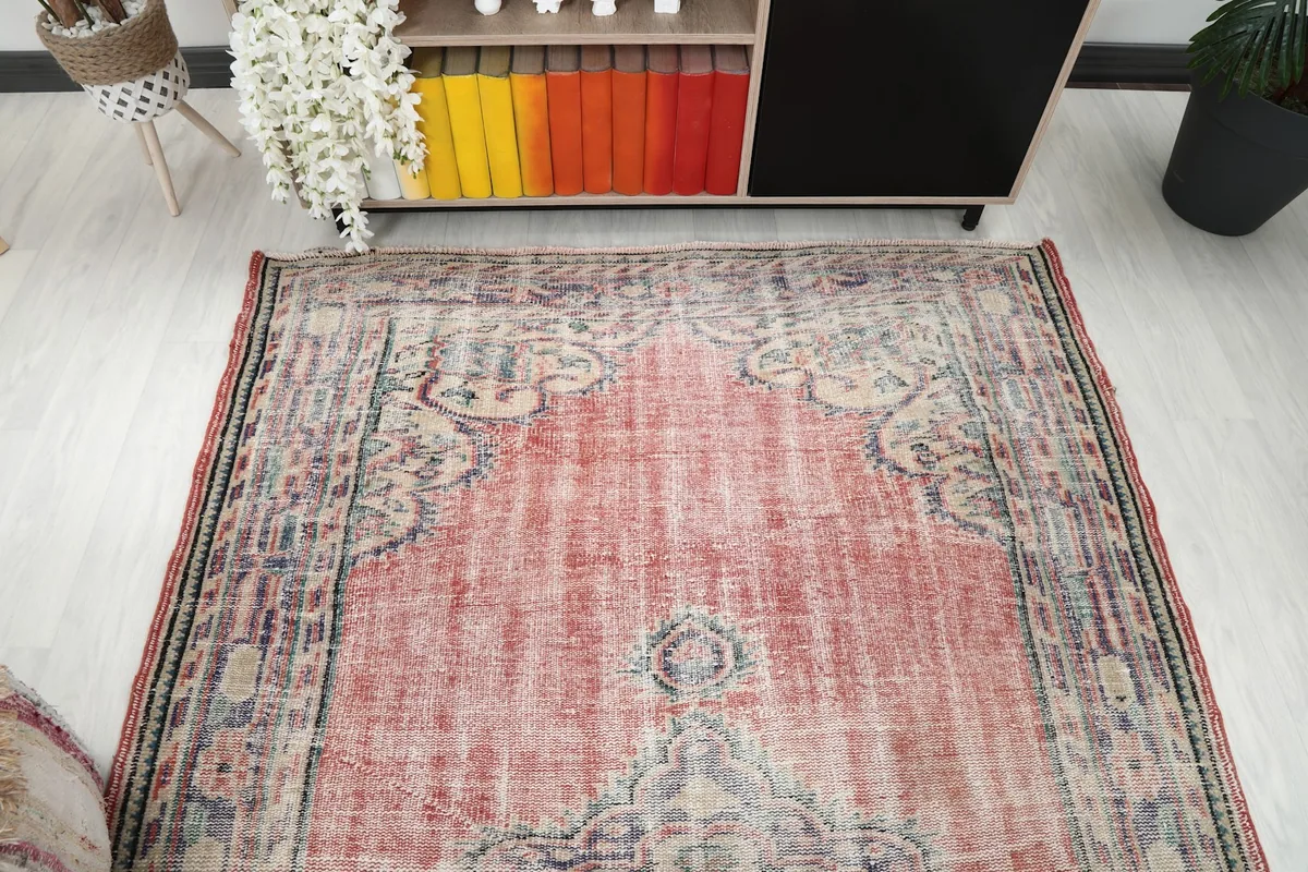Overhead view of the vintage rug, emphasizing its rectangular shape and central design.
