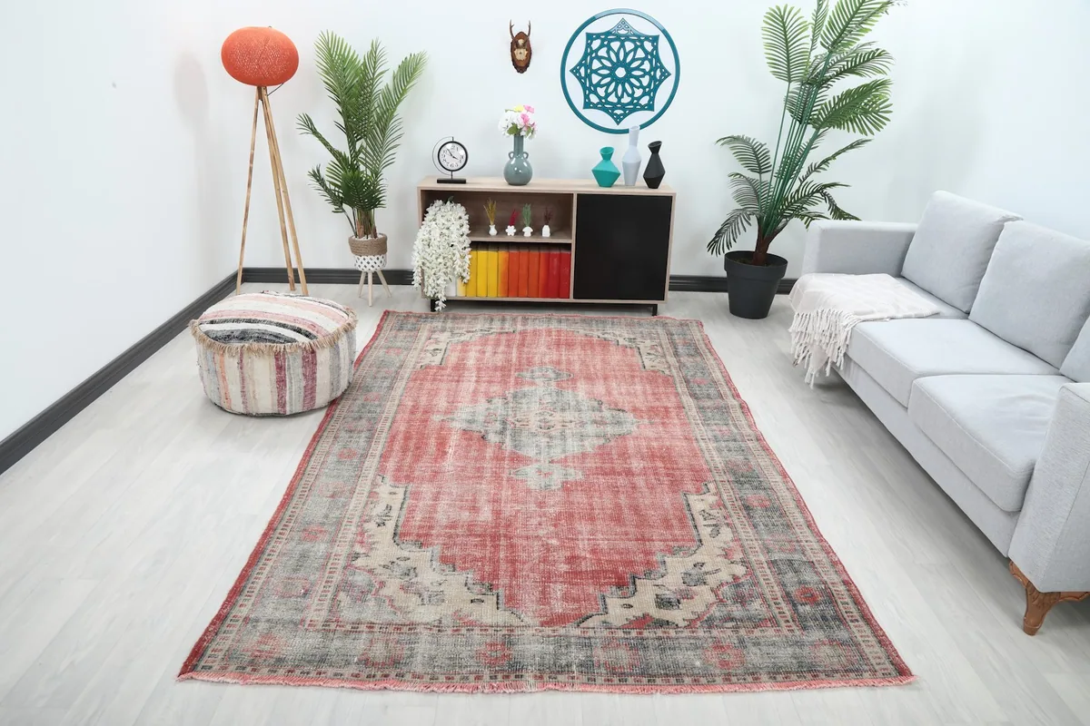 Vintage rug with rose field and gray medallion placed in a modern living room setting