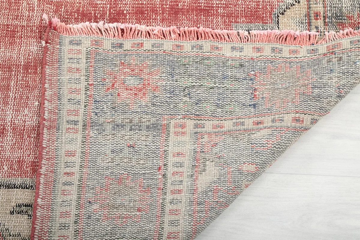 Underside view of the rug's cotton foundation and the hand-knotted construction
