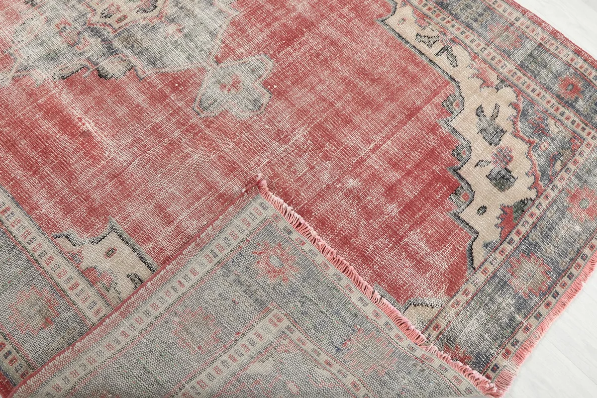 Folded corner of the rug revealing the back of the hand-knotted cotton foundation and wool pile