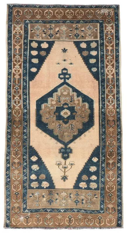 Full top view of the 4x7 vintage Anatolian rug with a beige field and navy medallion