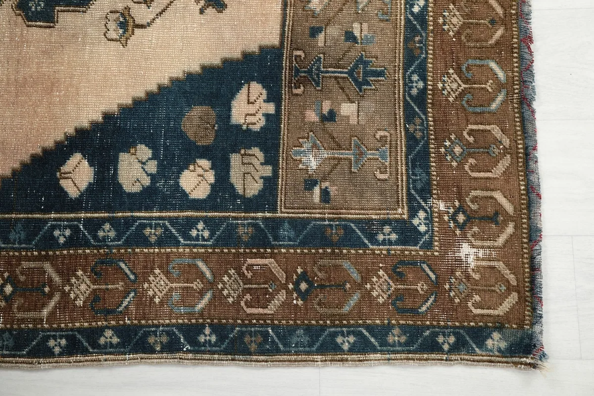 Detailed view of the corner border and field patterns, highlighting the patina