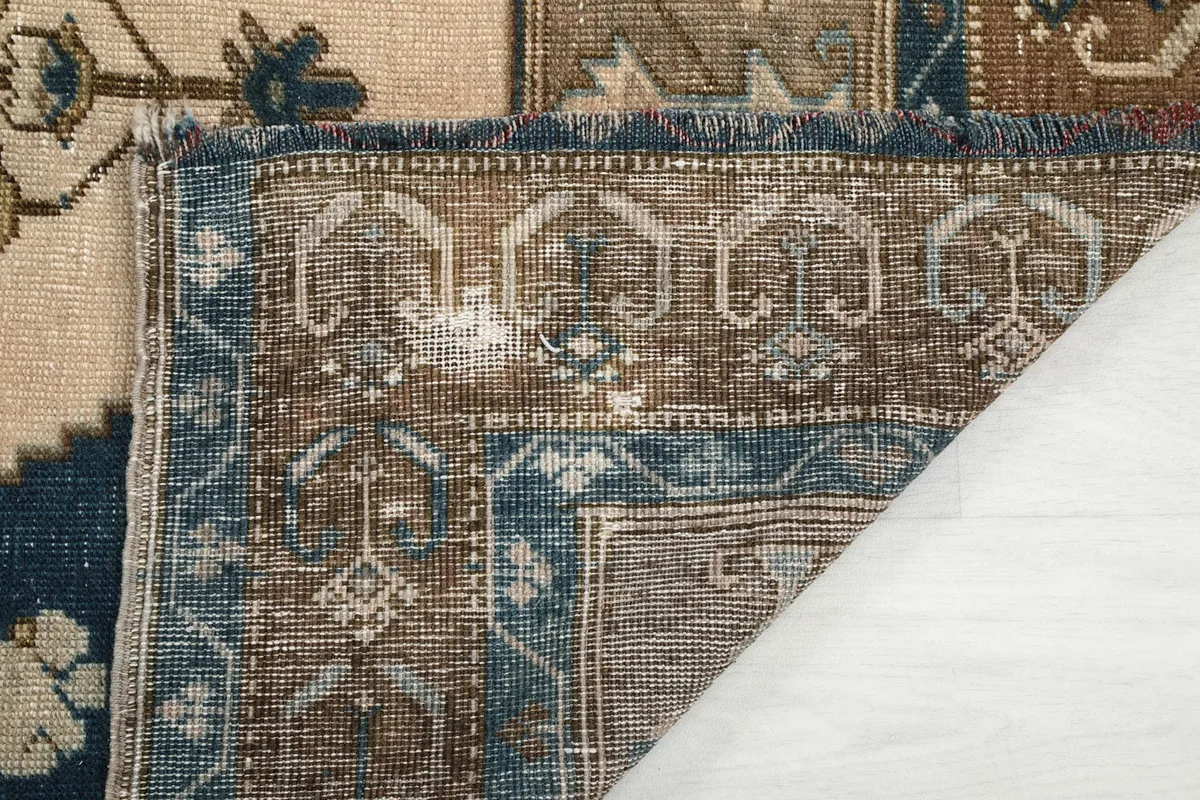 Underside of the rug's corner, showing the cotton foundation and knotting
