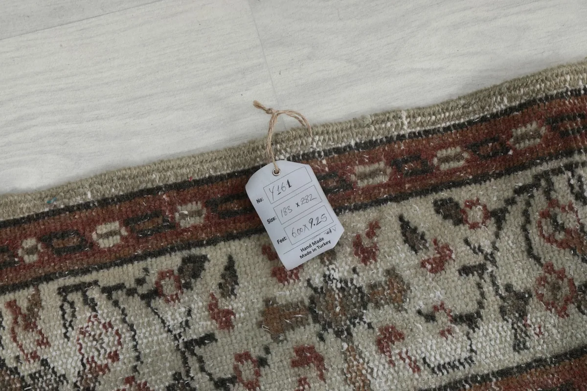 Detail of the rug's edge with a product tag, indicating its origin and material