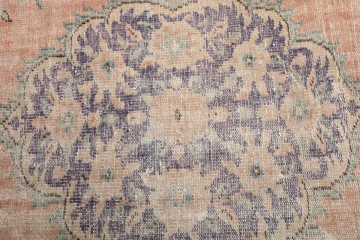 Tight close-up of the central purple and gold medallion motif, showing texture and wear