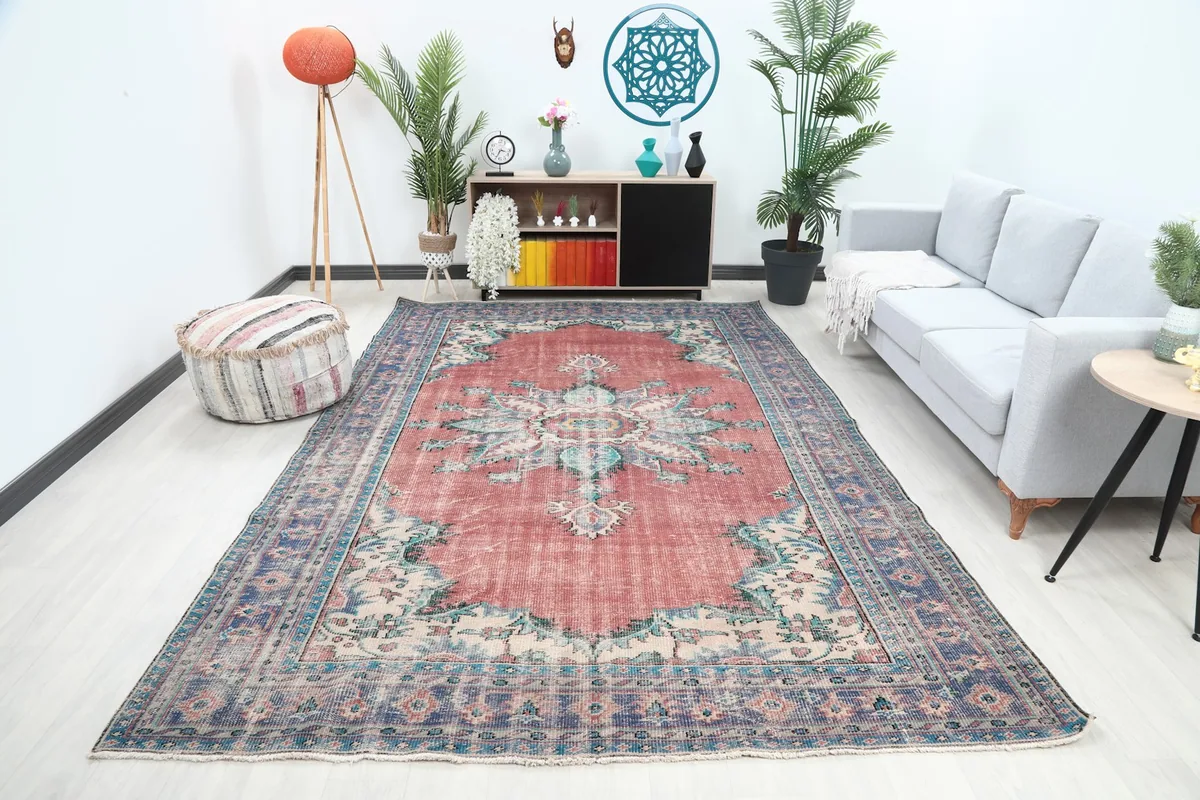 Vintage rust and blue Anatolian rug displayed in a bright living room setting