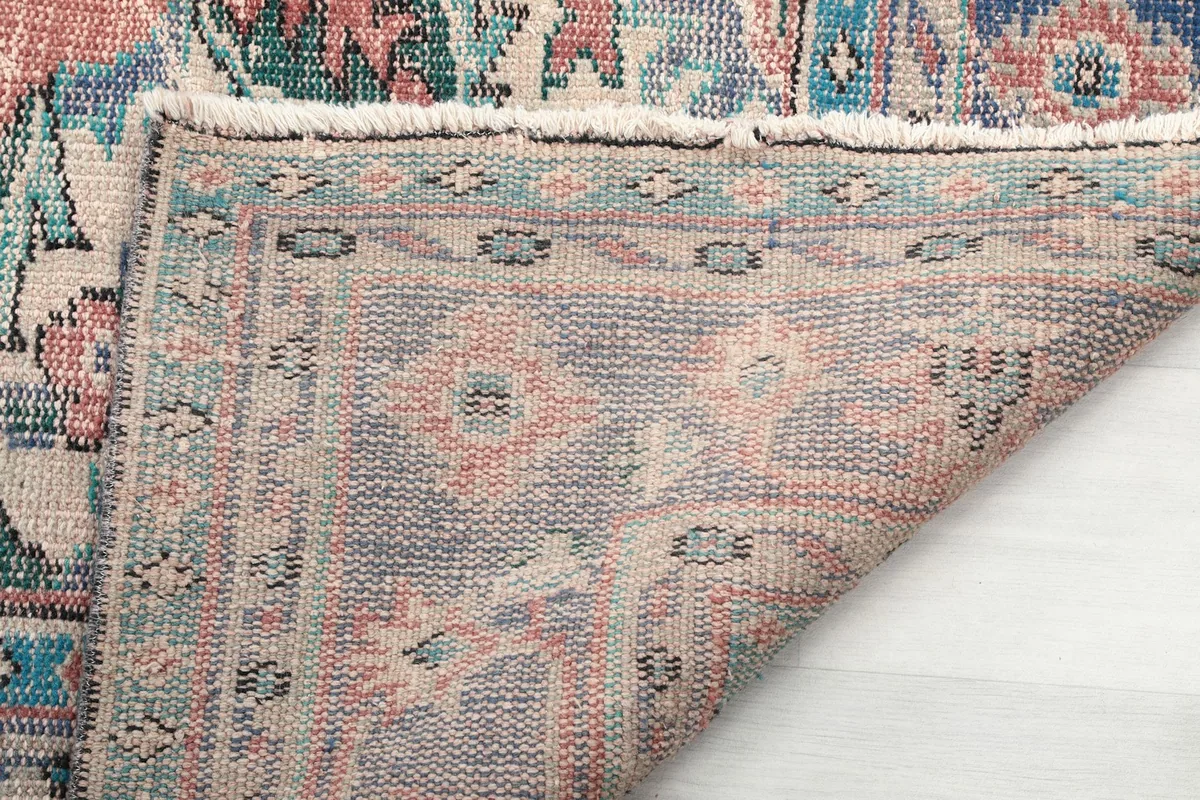 Underside of the rug revealing the hand-knotted construction and fringe