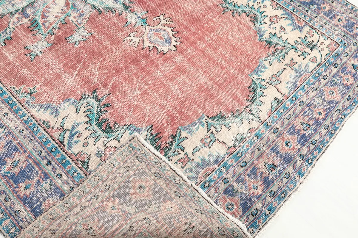 Corner of the rug folded back to show the cotton foundation and knotting